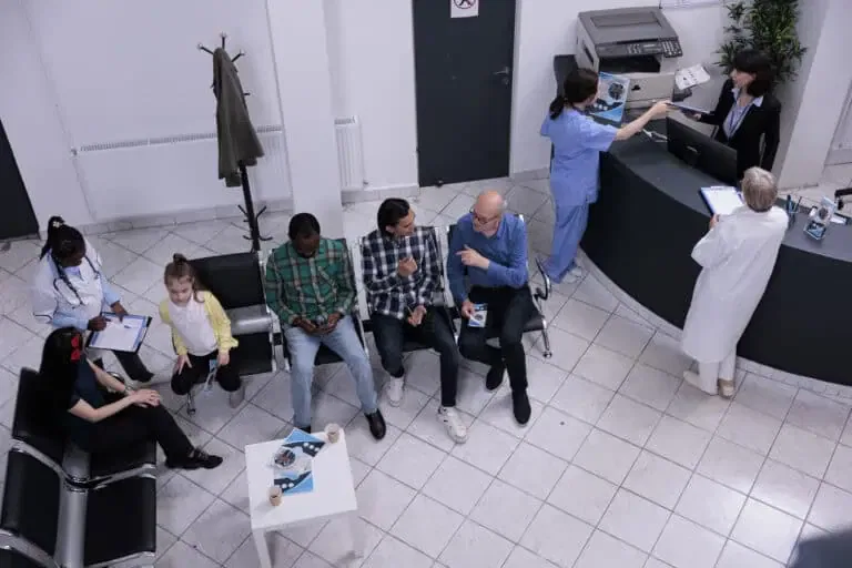 top view hospital reception diverse group people waiting doctor appointment while talking about medical problems professional nurse checking appointment mother child