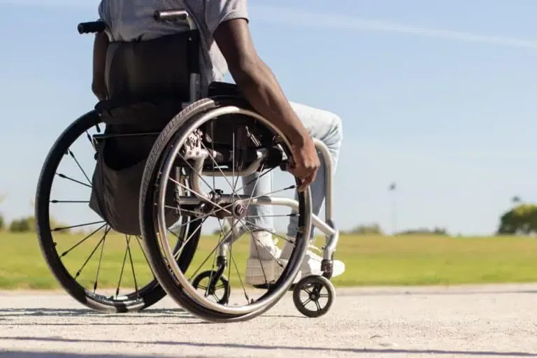black man wheelchair riding along park road 1