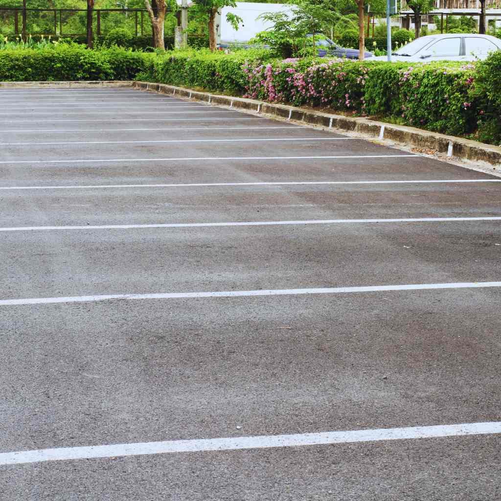 reshly striped parking lot with clear stall lines and landscaped borders — illustrating the importance of ADA-compliant parking layout and maintenance verified through CASp inspections in Fresno.