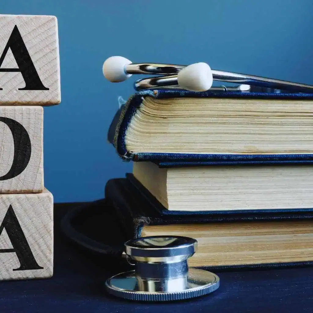 Stack of ADA and accessibility law books with a stethoscope placed beside them, symbolizing the legal and technical requirements behind California CASp inspection costs.
