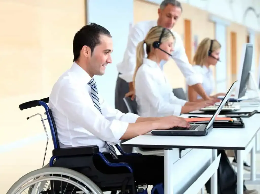 guy in wheelchair sitting at desk in office