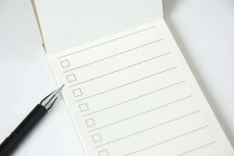 blank list planner with checklist black pen white background close up