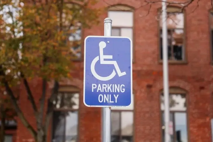 blue white handicap parking sign against blurred urban backdrop symbolizing accessibility 871349 12647