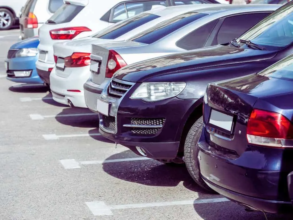 Row of parked cars in a California commercial parking lot with clearly marked stalls for ADA compliance