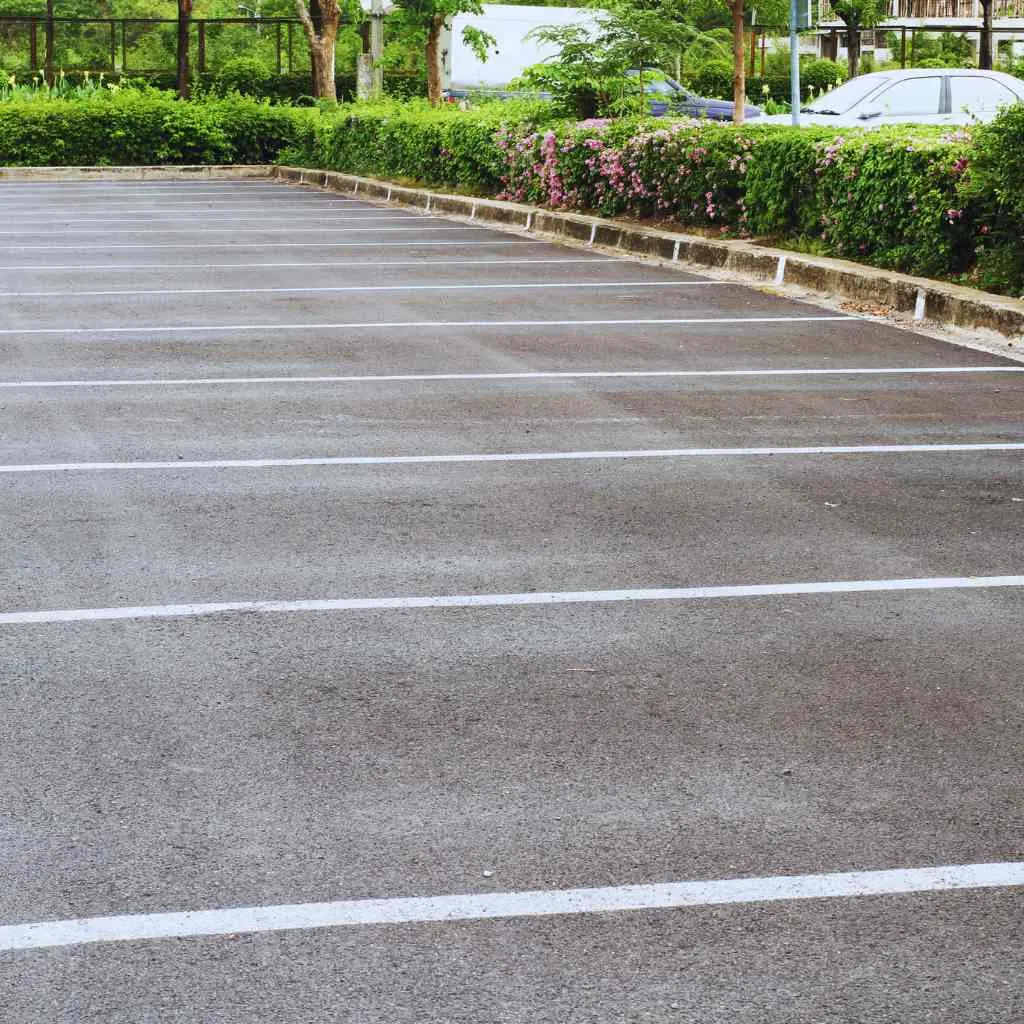 reshly striped parking lot with clear stall lines and landscaped borders — illustrating the importance of ADA-compliant parking layout and maintenance verified through CASp inspections in Fresno.